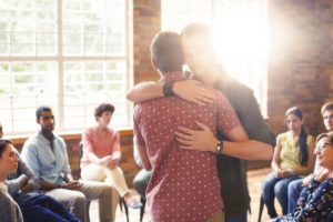 two guys hugging in intensive outpatient program